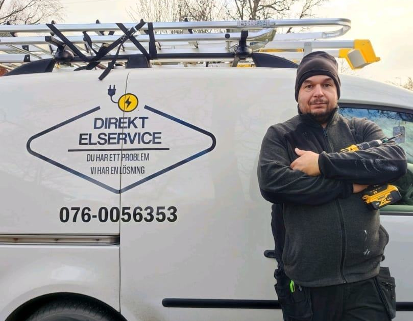 Din elektriker bredvid Direkt Elservices servicebil med företagets logotyp